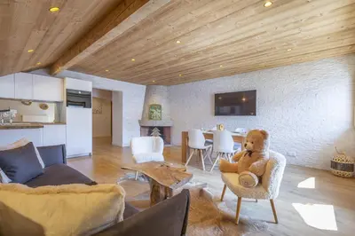 a teddy bear sitting in a chair in a living room at Résidence Le Panorama - Megève in Megève