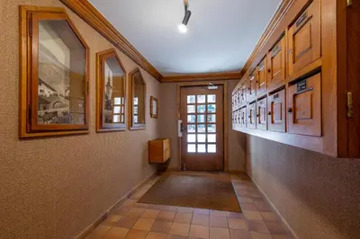 a hallway with a door and some pictures on the wall at Résidence Le Panorama - Megève in Megève