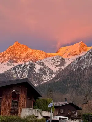 a snow covered mountain in front of a house at Appartement Alpage in Les Houches