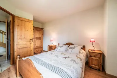 a bedroom with a bed and two night stands with lamps at La Ferme de Sous-Lachat in Samoëns