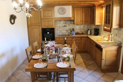 a kitchen with a wooden table with chairs and a tableablish at La Ferme de Sous-Lachat in Samoëns