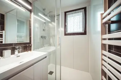 a white bathroom with a sink and a shower at Studio Lanchettes - Your stay at the gates of Megève in Demi-Quartier