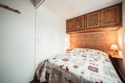 a bedroom with a bed with a quilt on it at Studio Lanchettes - Your stay at the gates of Megève in Demi-Quartier
