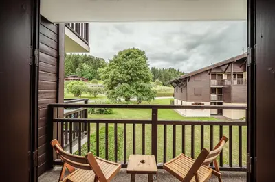 a balcony with two chairs and a table at Studio Lanchettes - Your stay at the gates of Megève in Demi-Quartier