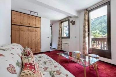 a living room with a couch and a glass table at Apartment l'Aiguille, au pied des télécabines in Chamonix-Mont-Blanc