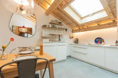 a kitchen with white cabinets and a wooden table at Nid douillet rénové sur les pistes ski in out in Megève