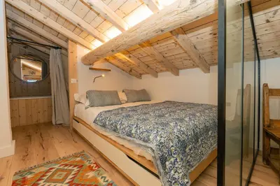 a bedroom with a bed in a room with wooden ceilings at Nid douillet rénové sur les pistes ski in out in Megève