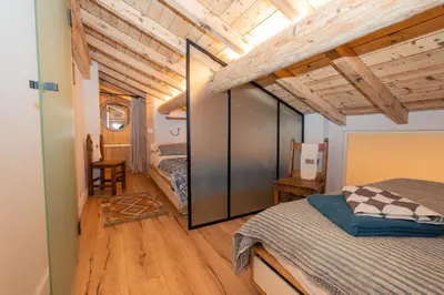 a bedroom with a bed in a room with wooden ceilings at Nid douillet rénové sur les pistes ski in out in Megève
