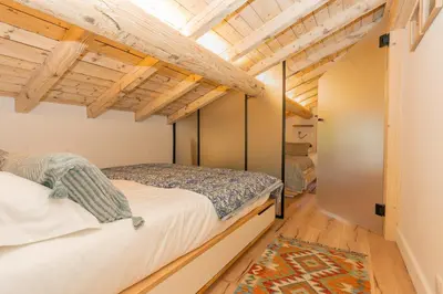 a bedroom with a bed and wooden ceilings at Nid douillet rénové sur les pistes ski in out in Megève