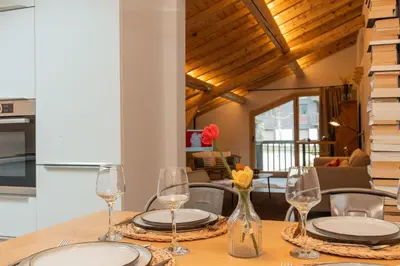 a table with plates and glasses on top of it at Nid douillet rénové sur les pistes ski in out in Megève