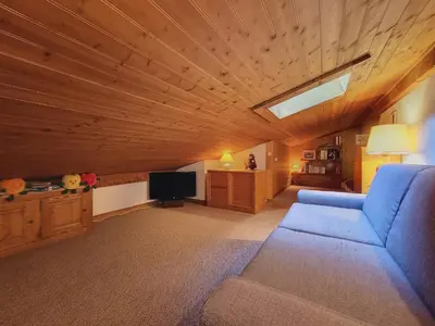a living room with a blue couch and a television at Duplex 2 pièces avec balcon et Wifi face au Mont Blanc - FR-1-560-165 in Combloux