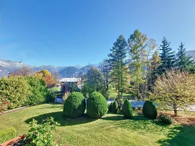 a garden with a row of bushes and trees at Duplex 2 pièces avec balcon et Wifi face au Mont Blanc - FR-1-560-165 in Combloux