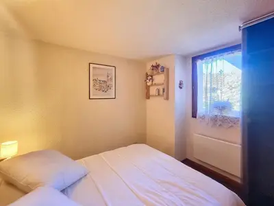 a small bedroom with a bed and a window at Duplex 2 pièces avec balcon et Wifi face au Mont Blanc - FR-1-560-165 in Combloux