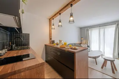 a bedroom with a white bed with a wooden headboard at Cosy nest with balcony in the middle of Argentière in Chamonix-Mont-Blanc