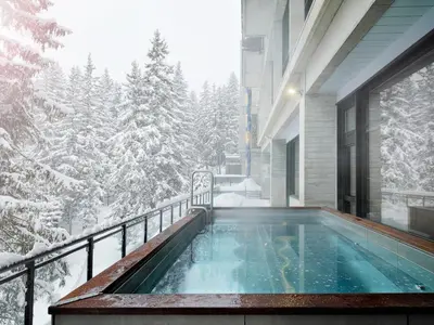 two women sitting at a table holding glasses at Totem, Friendly Hotel & Spa in Flaine