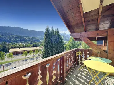 a balcony with tables and chairs and a view at TRAA15 Appartement 3 pieces proximite ski bus in Les Carroz d'Araches
