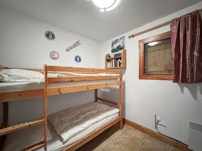 a bedroom with two bunk beds and a window at TRAA15 Appartement 3 pieces proximite ski bus in Les Carroz d'Araches