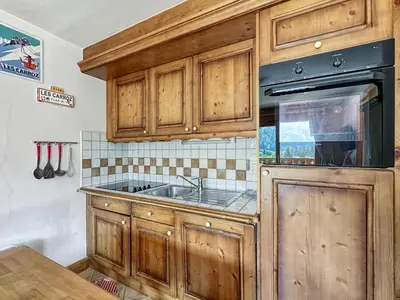 a kitchen with wooden cabinets and a sink at TRAA15 Appartement 3 pieces proximite ski bus in Les Carroz d'Araches
