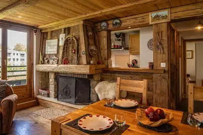 a living room with a table and a fireplace at La Cachette - Mountain style and spacious 2-Bed apartment central Chamonix in Chamonix-Mont-Blanc