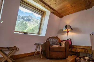 a room with a chair and a window at La Cachette - Mountain style and spacious 2-Bed apartment central Chamonix in Chamonix-Mont-Blanc