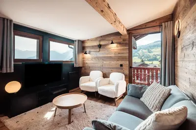 a living room with a couch and two chairs and a television at Le Cocon - Balcon sur le Mont-Blanc in Combloux
