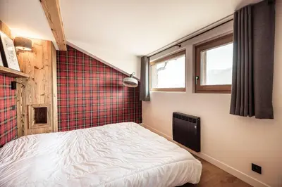 a bedroom with a bed and a red wall at Le Cocon - Balcon sur le Mont-Blanc in Combloux