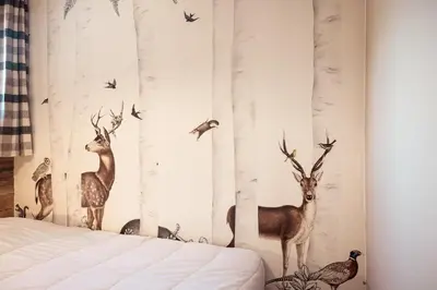 a bedroom with a wall mural of deer and birds at Le Cocon - Balcon sur le Mont-Blanc in Combloux