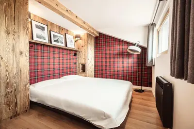 a bedroom with a bed and a red wall at Le Cocon - Balcon sur le Mont-Blanc in Combloux