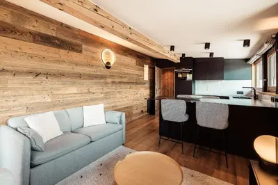a living room with a couch and a kitchen at Le Cocon - Balcon sur le Mont-Blanc in Combloux