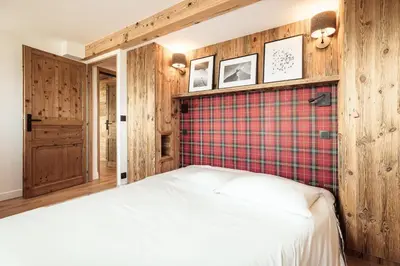 a bedroom with a bed and a plaid wall at Le Cocon - Balcon sur le Mont-Blanc in Combloux