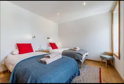 two beds in a room with white walls and red pillows at Beautiful 2BR in Chamonix Centre in Chamonix-Mont-Blanc