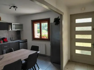 a kitchen with a table and a window and a door at Maison La Pallud in Domancy