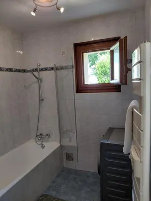 a bathroom with a bath tub and a window at Maison La Pallud in Domancy