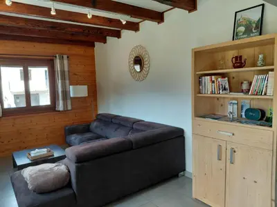 a living room with a couch and a book shelf at Maison La Pallud in Domancy
