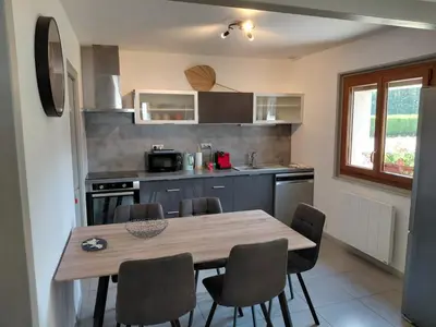 a kitchen with a wooden table and chairs at Maison La Pallud in Domancy