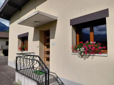 a balcony of a house with flowers in a window at Maison La Pallud in Domancy