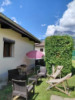 a group of chairs and an umbrella in a yard at Maison La Pallud in Domancy