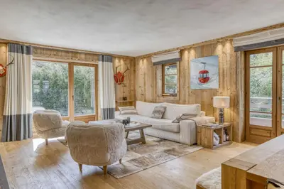 a living room with a couch and chairs and windows at Glacier in Megève