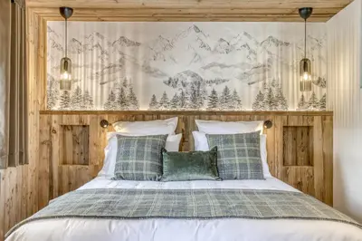 a bedroom with a bed with a mountain mural on the wall at Glacier in Megève
