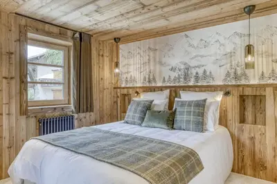 a bedroom with a large bed with wooden walls at Glacier in Megève
