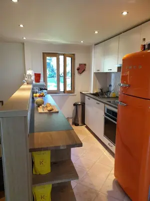 a kitchen with an orange refrigerator and a counter at Amazing Mt Blanc View 2 Bed, Parking, 10mins walk in Chamonix-Mont-Blanc