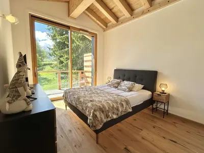 a bedroom with a bed and a large window at Appartement 3 Pièces, 4-6 couchages, COMBLOUX COM100-A402 in Combloux