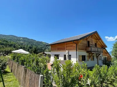 a house in a vineyard with a fence at Chalet avec Jacuzzi vue Dômes de Miage in Bionnay