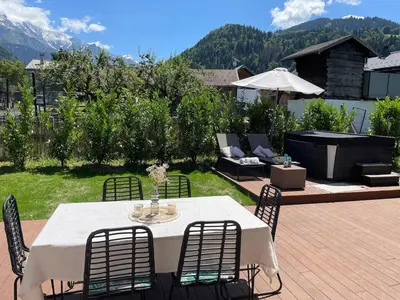 a table and chairs sitting on a patio at Chalet avec Jacuzzi vue Dômes de Miage in Bionnay
