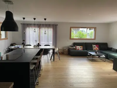 a kitchen and living room with a couch and a table at Chalet avec Jacuzzi vue Dômes de Miage in Bionnay