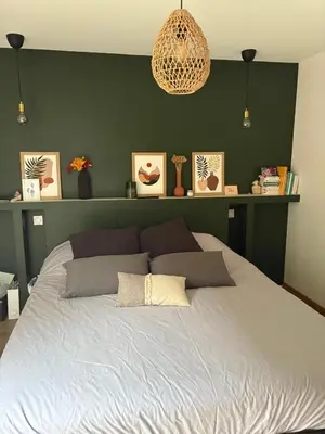 a bedroom with a large bed with a green wall at Chalet avec Jacuzzi vue Dômes de Miage in Bionnay