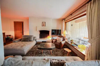 a wooden table in a room with a large window at Chalet Merveille - Proche centre ville de Megève in Megève