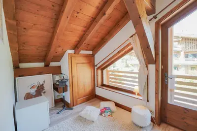 a tiny house with a large window in a room at Chalet Merveille - Proche centre ville de Megève in Megève