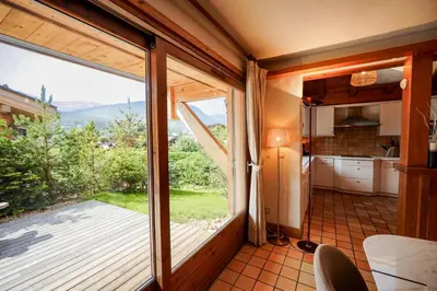 a wooden deck with a table and chairs on a house at Chalet Merveille - Proche centre ville de Megève in Megève