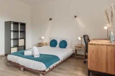 a bedroom with a large white bed with blue pillows at Le Montagny Sejour Cosy au Coeur des Alpes in Sallanches